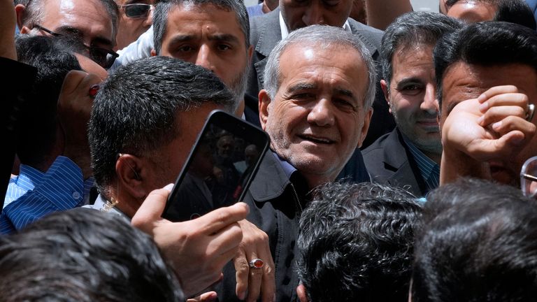 Reformist candidate for the Iran's presidential election Masoud Pezeshkian is greeted by his supporters as he arrives to vote at a polling station in Shahr-e-Qods near Tehran, Iran, Friday, July 5, 2024. Iranians are voting in a runoff election to replace the late President Ebrahim Raisi, who was killed in a May helicopter crash in the country...s northwest along with the foreign minister and several other officials. (AP Photo/Vahid Salemi)