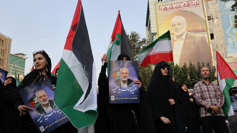 People in Tehran hold Palestinian flags as they attend an anti-Israel gathering following the killing of Hamas's leader Ismail Haniyeh. Pic: Reuters