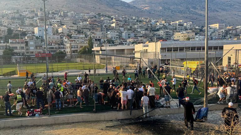 Residence and paramedics rush to help children moments after a rocket attack hit a football pitch in the Druze town of Majdal Shams in the Israeli-controlled Golan of Heights. Pic: AP