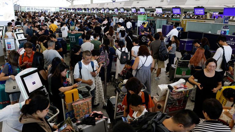 Hong Kong Express Airways passengers queue at counters in Hong Kong International Airport amid system outages disrupting the airline's operations, in Hong Kong, China, July 19, 2024. REUTERS/Tyrone Siu