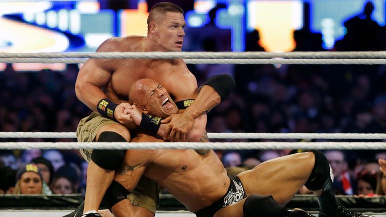 FILE - Wrestler John Cena, top, chokes Dwayne "The Rock" Johnson at a Wrestlemania event, April 7, 2013, in East Rutherford, N.J. Dwayne “The Rock” Johnson is back to perform in one of the main events this weekend's WrestleMania in Philadelphia (AP Photo/Mel Evans, File)