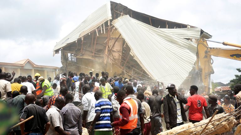 People and rescuers gather at the scene of a collapsed two-storey building in Nigeria. Pic: AP