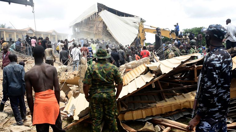 People gather at the scene of a collapsed two-storey building in Jos. Pic: AP