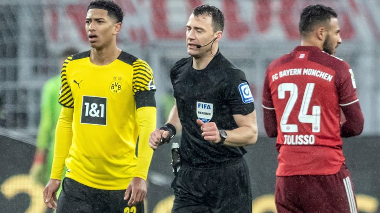 04 December 2021, North Rhine-Westphalia, Dortmund: 04.12.2021, North Rhine-Westphalia, Dortmund: Football, Bundesliga, Borussia Dortmund - FC Bayern Munich, Matchday 14 at Signal Iduna Park. Referee Felix Zwayer (M) walks past Dortmund's Jude Bellingham to the side of the pitch to watch the video evidence for the penalty kick that is subsequently given. Bayern's Corentin Tolisso is on the right. Photo by: Bernd Thissen/picture-alliance/dpa/AP Images


