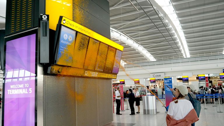 Departure boards ae covered in orange paint. Pic: Just Stop Oil