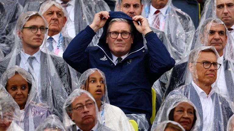 Keir Starmer shelters from the rain