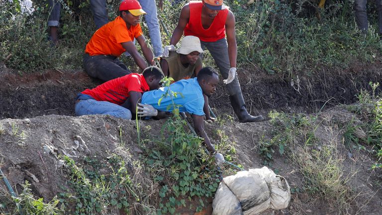 Volunteers recover the body of a person from the quarry. Pic: Reuters