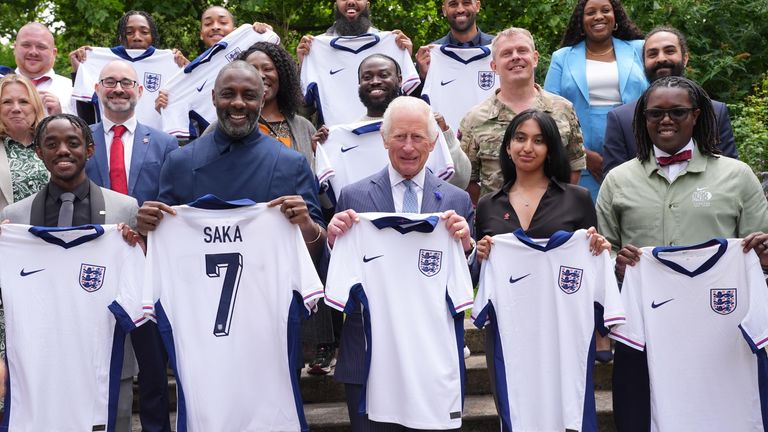 King Charles and Idris Elba hold England football team shirts.
Pic: PA