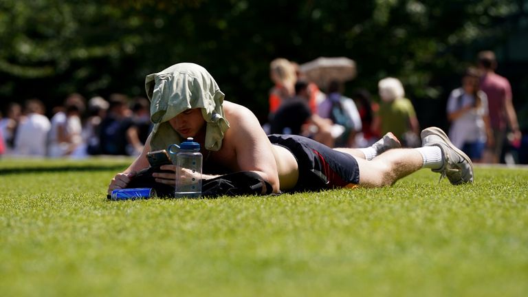 A man sunbathes with his t-shirt covering his head, enjoying the hot weather, in London Bridge. South-eastern England is likely to see the UK's hottest day of the year so far on Friday, although the UK as a whole will face a mixed picture on Friday and into the weekend. Picture date: Friday July 19, 2024.