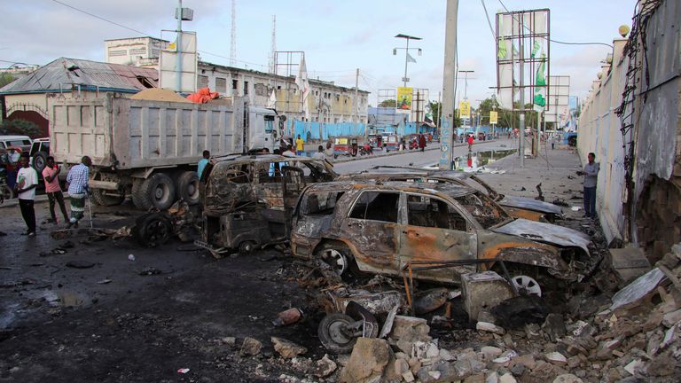People gather near the wreckages of vehicles destroyed at the scene of an explosion outside a restaurant where patrons were watching the final of the Euro 2024 football tournament on TV, in Bondhere district of Mogadishu, Somalia July 15, 2024. REUTERS/Feisal Omar
