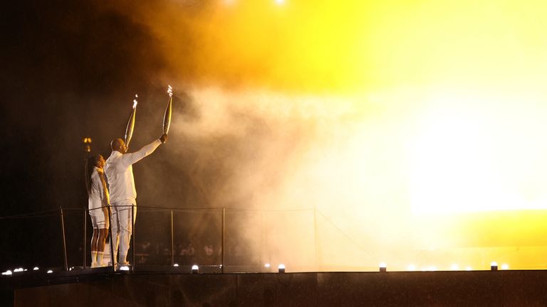 Paris 2024 Olympics - Opening Ceremony - Paris, France - July 26, 2024. The Olympic torches are held during the lighting of the Olympic cauldron at the opening ceremony. REUTERS/Marko Djurica
