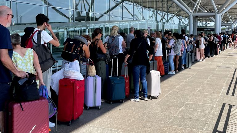 Passengers queue outside Stansted Airport amid the global outage. Pic: PA