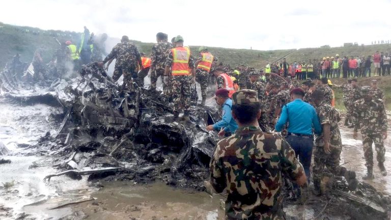 Emergency services work at the accident site of the Saurya Airlines plane that caught fire after skidding off the runway. Pic:NepaliArmyHQ/Reuters