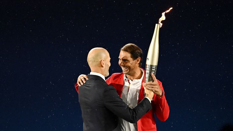 Zinedine Zidane passes the Olympic torch to tennis player Rafael Nadal.
Pic Reuters