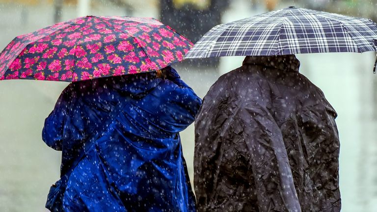 People in Liverpool protect themselves from the rain. Heavy rain could bring flooding and travel disruption across much of the UK on Wednesday and Thursday with an amber warning issued for part of the country. Picture date: Wednesday May 22, 2024.