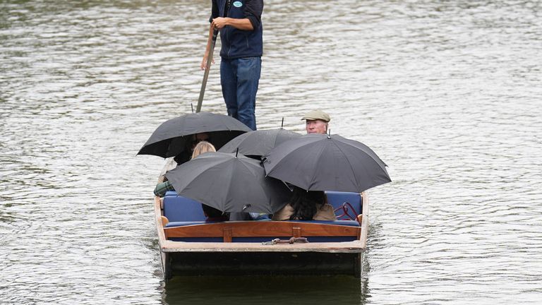 People shelter from the rain under umbrellas as they punt along the River Cam in Cambridge last week. Pic: PA
