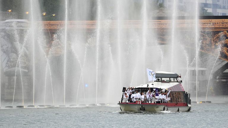 Athletes of Refugee Olympic Team aboard a boat in the floating parade.
Pic: Reuters