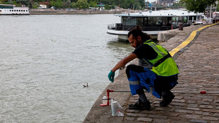 A municipal employee demonstrates the sampling of the water of the River Seine near the Notre-Dame de Paris Cathedral during a press presentation ahead of the Paris 2024 Olympics and Paralympics Games in Paris, France, July 15, 2024. REUTERS/Gonzalo Fuentes