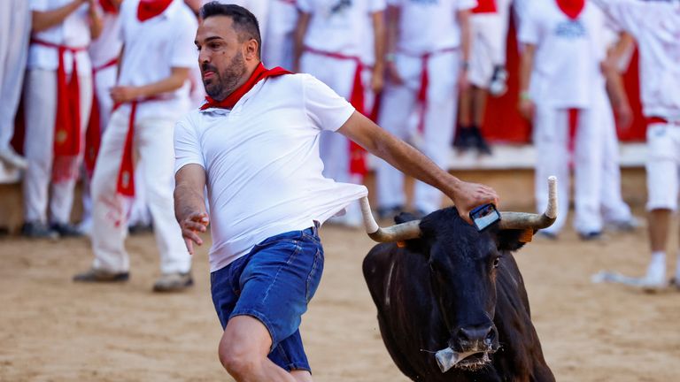A reveller sprints as a bull runs at the San Fermin festival in Pamplona. Pic: Reuters