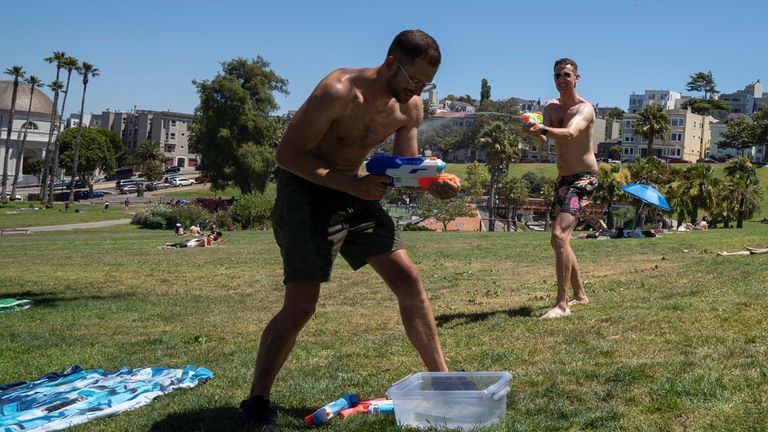 Vincent Thomas and David Deaton squirt each other with water guns in San Francisco, California, Pic: Reuters