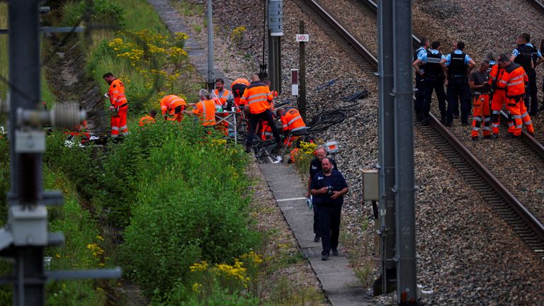 Rail workers and police officers at a site targeted by arsonists in northern France. Pic: Reuters