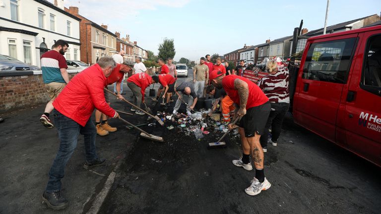 Volunteers sweep Sussex road, after violent protest following a vigil for victims of the knife attack in Southport, Britain July 31, 2024. REUTERS/Temilade Adelaja
