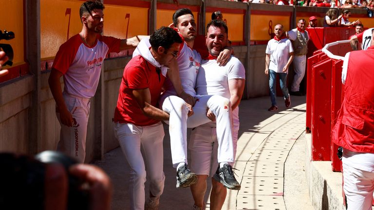 A recortador is carried off after being gored at the festival. Pic: AP