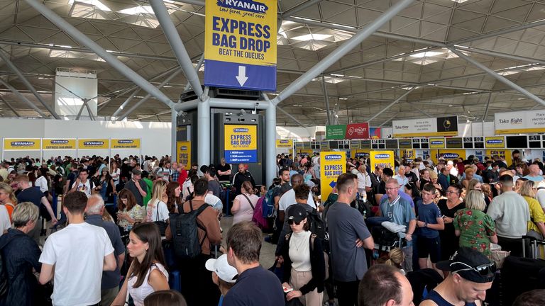 Passengers queue by the Ryanair check-in desk at Stansted. Pic: PA