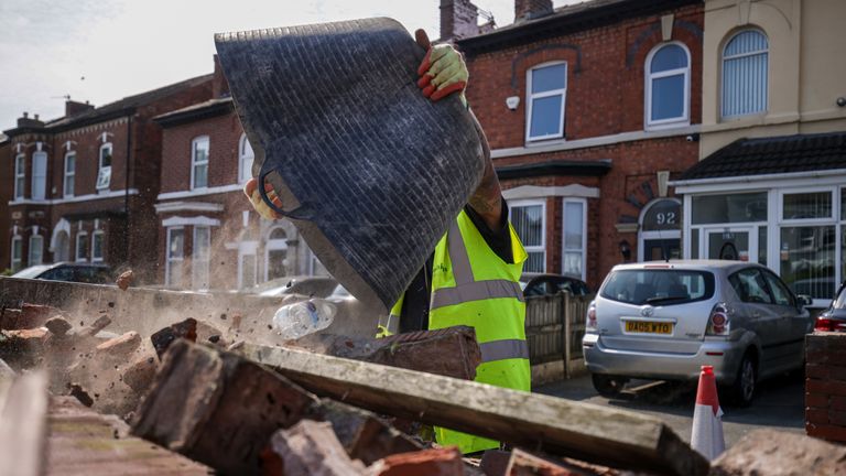 Debris is removed from a damaged wall on Sussex Road.  Photo: PA