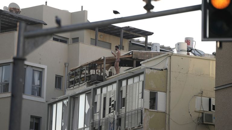 A man films the scene after a deadly explosion, from his rooftop in Tel Aviv. Pic: AP