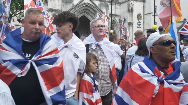 Tommy Robinson supporters draped in St George's and Union Jack flags outside the Royal Courts of Justice in London