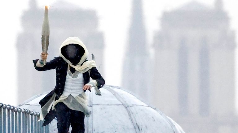 The  torchbearer runs atop the Musee d'Orsay.
Pic: Reuters