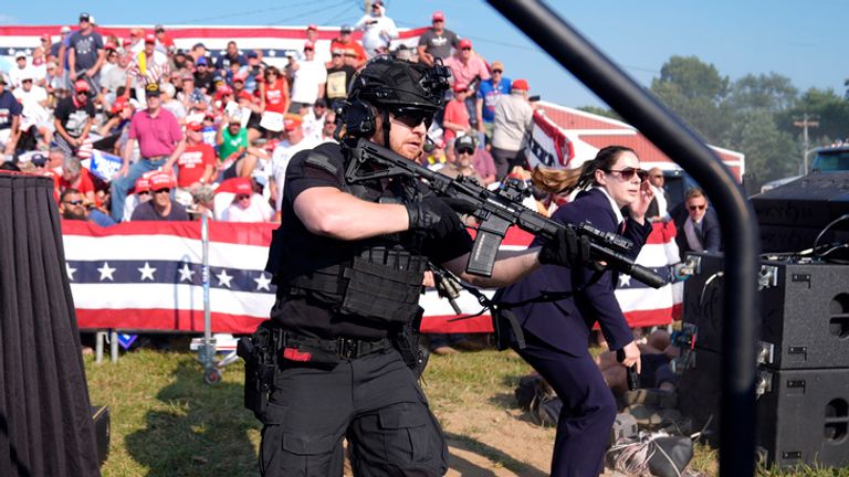 Secret service agents storm the stage. Image: AP