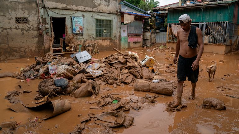 A man walks past mud and debris following Typhoon Gaemi, in San Mateo town, Rizal province, Philippines. Pic: Reuters
