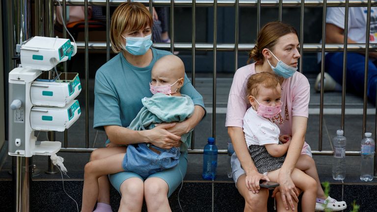 Mothers hold their children outside the Okhmatdyt hospital. Pic: Reuters