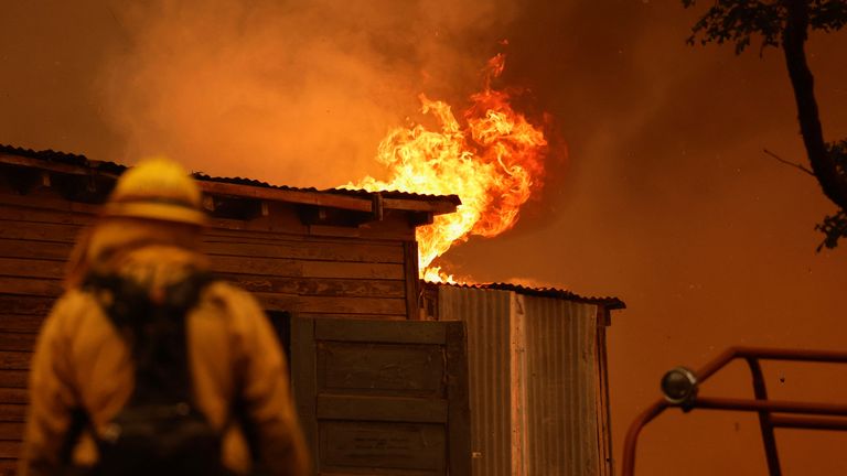 A firefighter works to save a burning structure amid the Park Fire. Pic: Reuters