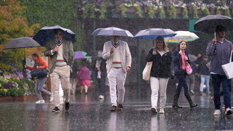 Spectators shelter from the rain on day five of the 2024 Wimbledon Championships at the All England Lawn Tennis and Croquet Club, London. Picture date: Friday July 5, 2024.