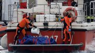 Rescue personnel pour water on a body bag containing the corpse of British entrepreneur Mike Lynch. Pic: Reuters