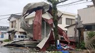 A metal object blown away by strong winds of a typhoon is caught on a power line in Miyazaki.
Pic: Kyodo News/Reuters