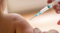 Doctor injecting a young child with a vaccination or antibiotic in a small disposable hypodermic syringe, close up of the kids arm and needle.