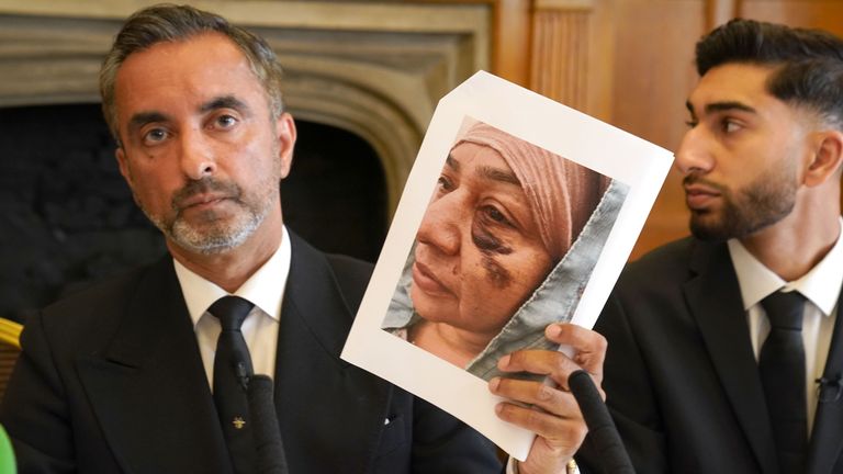 Lawyer Aamer Anwar shows a photo of Shameem Akhtar as his son Fahir Amaaz looks on.  Photo: PA