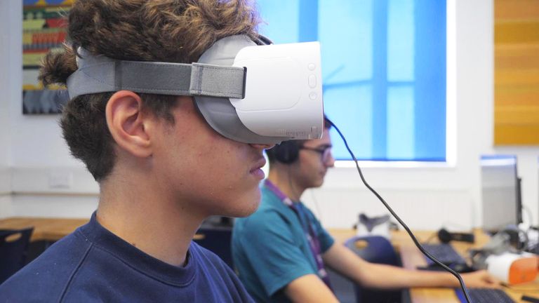 A student at David Game College uses VR goggles in the school's new AI classroom