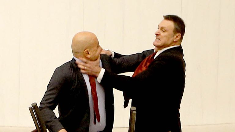 Turkey's AK Party lawmaker Alpay Ozalan scuffles with Workers' Party of Turkey (TIP) lawmaker Ahmet Sik, who was speaking during an extraordinary meeting of the Turkish parliament. Pic: Reuters