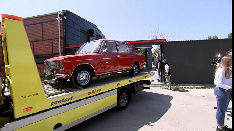 A vintage car is towed away from Tate's home