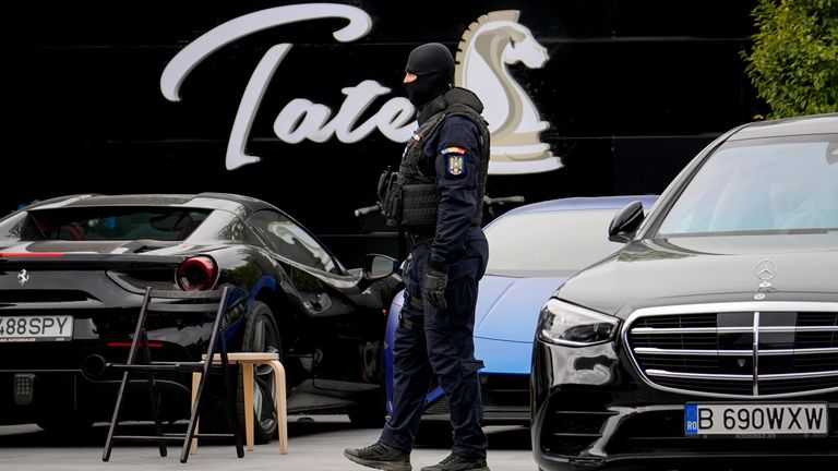 A masked gendarme patrols the courtyard of the residence of social media personality Andrew Tate during an early morning police search raid, on the outskirts of Bucharest, Romania, Wednesday, Aug. 21 2024. (AP Photo/ Vadim Ghirda)