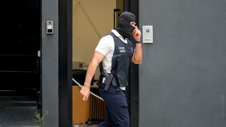 A police officer exits the residence of social media personality Andrew Tate during an early morning search raid, on the outskirts of Bucharest, Romania, Wednesday, Aug. 21 2024. (AP Photo/ Vadim Ghirda)