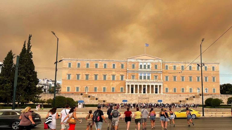 Smoke from wildfires is seen above the Greek parliament building in central Athens, Sunday, Aug. 11, 2024, after a blaze northeast of the capital forced evacuations in the area. (AP Photo/Derek Gatopoulos)