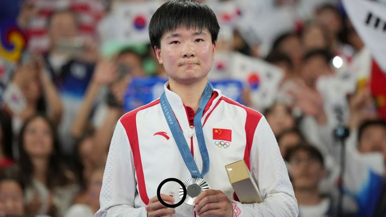 China's He Bingjiao celebrates on the podium after wining the silver medal at the badminton women singles at the 2024 Summer Olympics, Monday, Aug. 5, 2024, in Paris, France. (AP Photo/Kin Cheung)