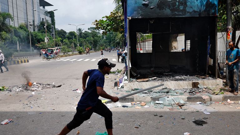 A demonstrator runs next to a vandalised police box. Pic: Reuters