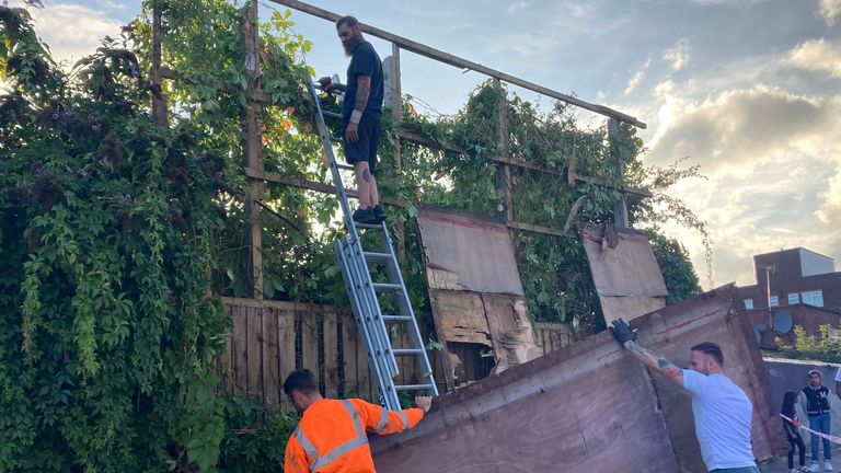 Contractors dismantle a billboard in Cricklewood, north-west London, with the new Banksy artwork depicting a stretching cat that was unveiled on Saturday. The elusive street artist confirmed he was behind the piece, a silhouette of a large cat with an upturned tail stretching out its body. Picture date: Saturday August 10, 2024.

